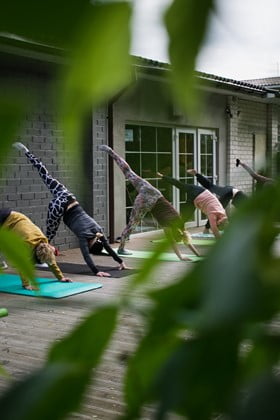 Udendørs træning, hvor folk står i en udstrækningspositur