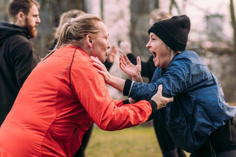 2 ekstremt begejstret Fysio Bootcamp deltagere, der træner udendørs på vores bootcamp