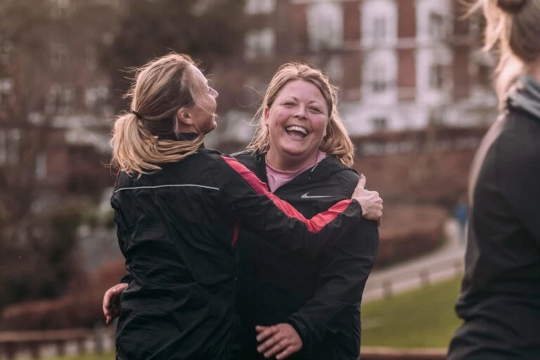 To glade bootcampdeltagere, der krammer hinanden