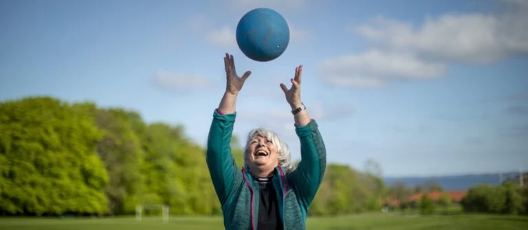 Majbritt, bootcampdeltager, kaster træningsbold i luften.jpgw3.webp
